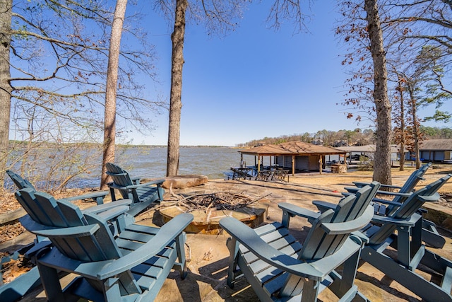 view of patio with a fire pit and a water view