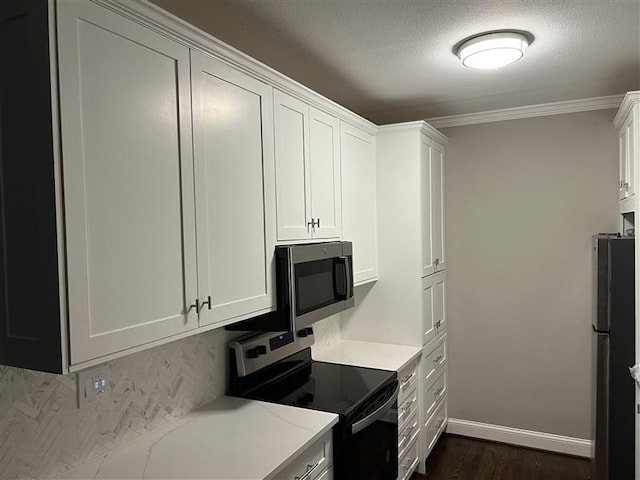 kitchen with baseboards, a textured ceiling, appliances with stainless steel finishes, and white cabinetry