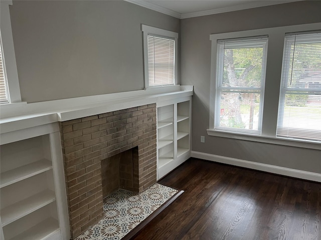 unfurnished living room with crown molding, a brick fireplace, dark wood-style flooring, and a wealth of natural light