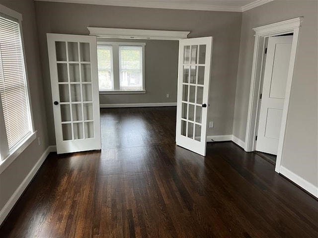 empty room featuring french doors, crown molding, baseboards, and dark wood-style flooring