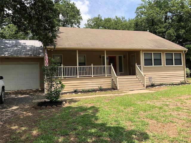 single story home with a porch, a front lawn, and a garage