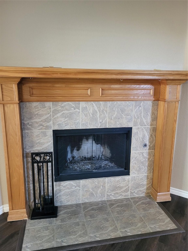 interior details featuring a tile fireplace