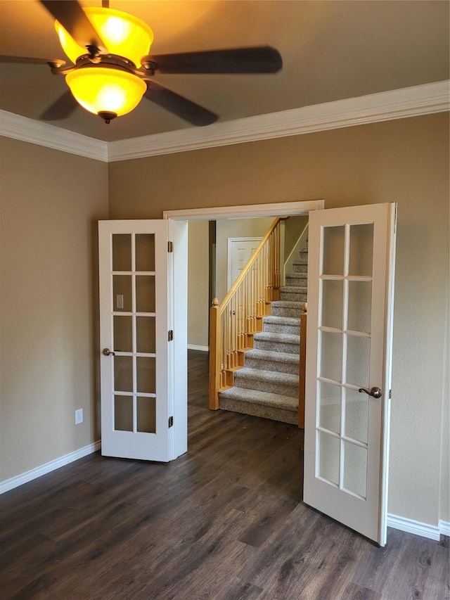 spare room featuring stairs, dark wood-type flooring, crown molding, and baseboards