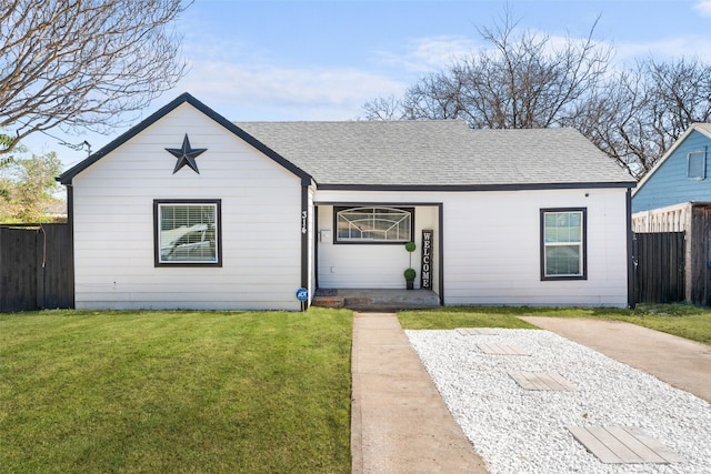 view of front of property with a shingled roof, a front lawn, and fence