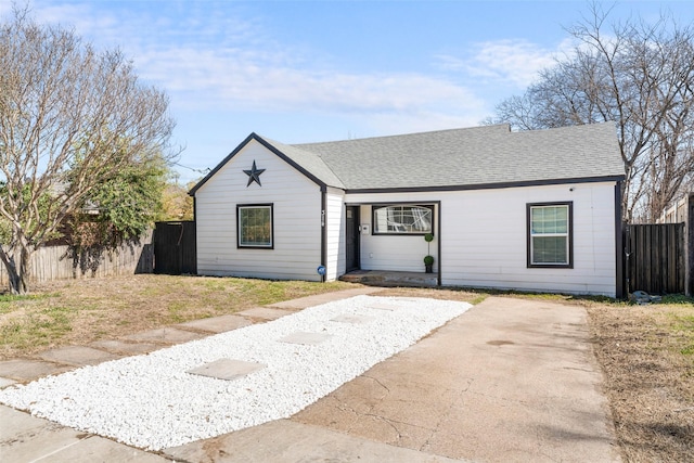 single story home with a shingled roof and fence