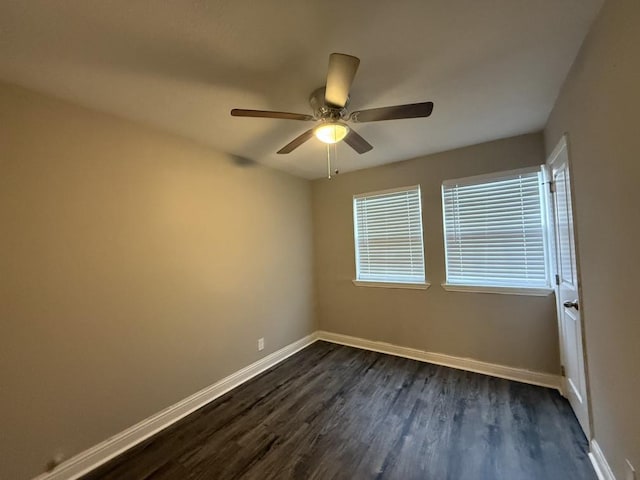 empty room featuring baseboards, a ceiling fan, and dark wood-style flooring