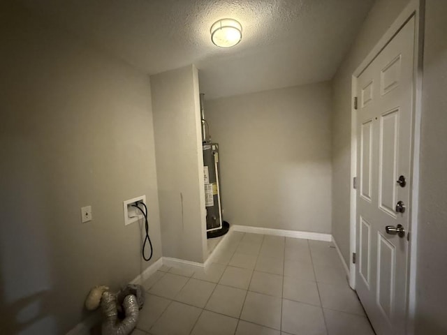 laundry area with baseboards, water heater, hookup for a washing machine, light tile patterned flooring, and a textured ceiling