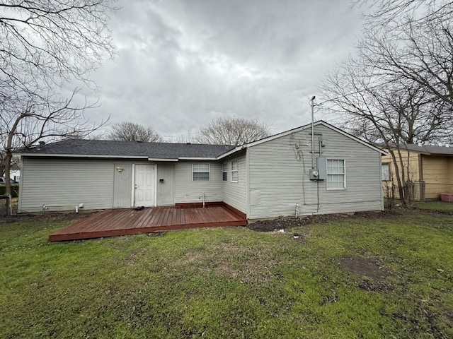 rear view of property with a yard and a deck