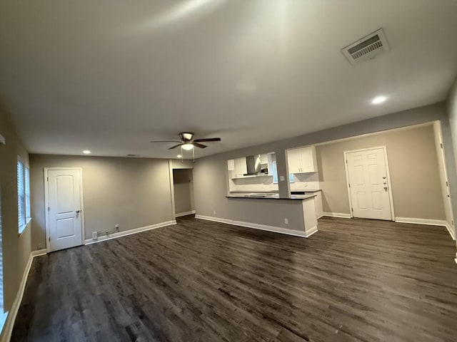 unfurnished living room with visible vents, a ceiling fan, baseboards, and dark wood-style flooring