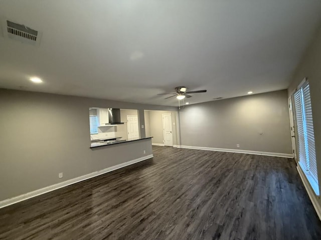 unfurnished living room with visible vents, a ceiling fan, dark wood-type flooring, and baseboards