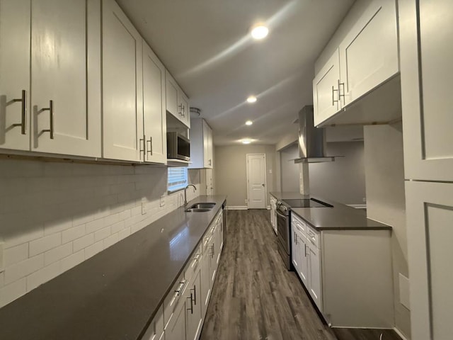 kitchen featuring dark countertops, decorative backsplash, exhaust hood, stainless steel appliances, and a sink