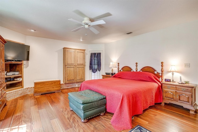 bedroom featuring light wood finished floors, visible vents, and ceiling fan