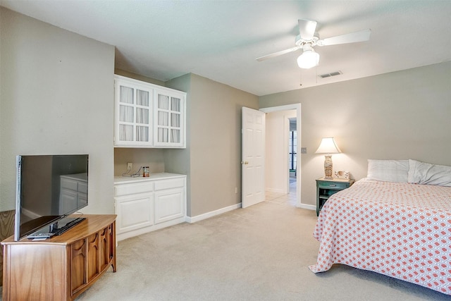 bedroom with a ceiling fan, baseboards, visible vents, and light carpet