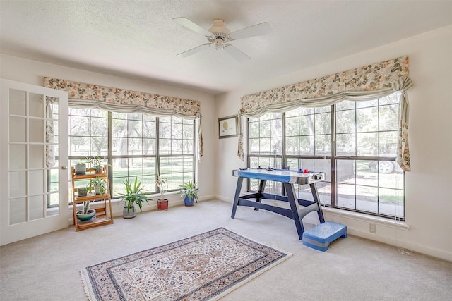 rec room with ceiling fan, baseboards, carpet floors, and a textured ceiling