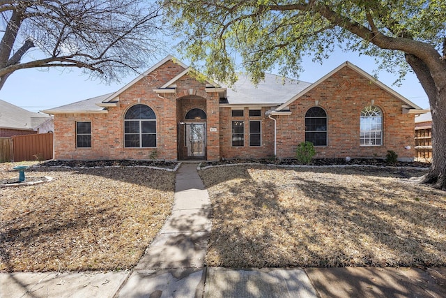 view of front of property featuring brick siding and fence