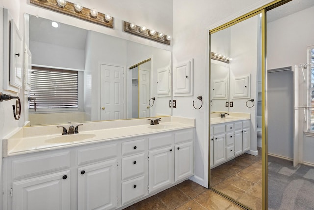 full bathroom with double vanity, plenty of natural light, and a sink