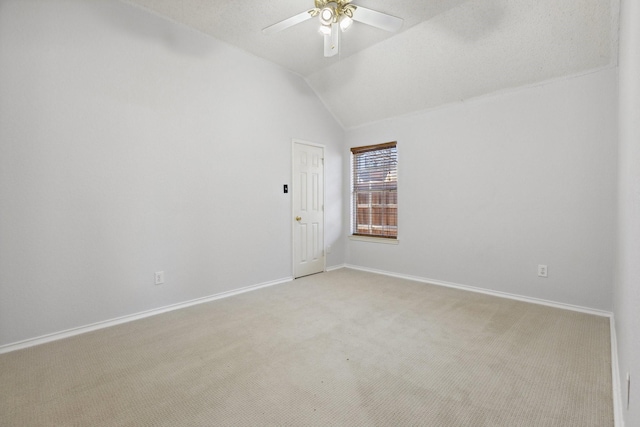 empty room with light carpet, ceiling fan, baseboards, and lofted ceiling