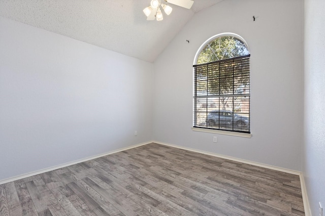 empty room with baseboards, a ceiling fan, lofted ceiling, and wood finished floors