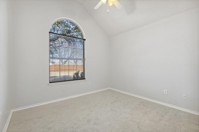 carpeted empty room featuring baseboards, a ceiling fan, and lofted ceiling