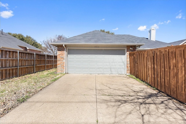 garage with driveway and fence