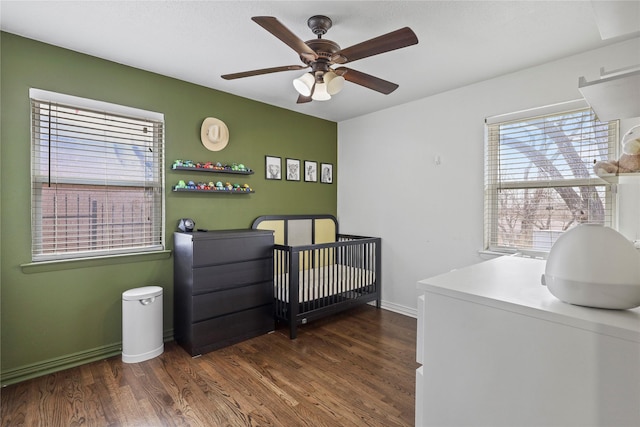 5621 Rocky Ridge Rd, Dallas, TX 75241 - bedroom featuring dark wood-type flooring, a nursery area, baseboards, and ceiling fan