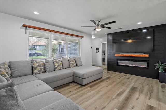 living area with visible vents, wood finished floors, recessed lighting, a large fireplace, and ceiling fan