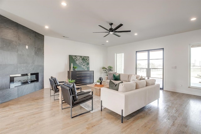 living area with visible vents, wood finished floors, recessed lighting, baseboards, and a tile fireplace