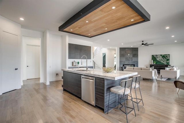 kitchen featuring a tile fireplace, dishwasher, modern cabinets, and a sink