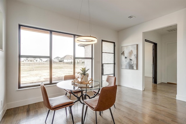 dining area with visible vents, baseboards, and wood finished floors