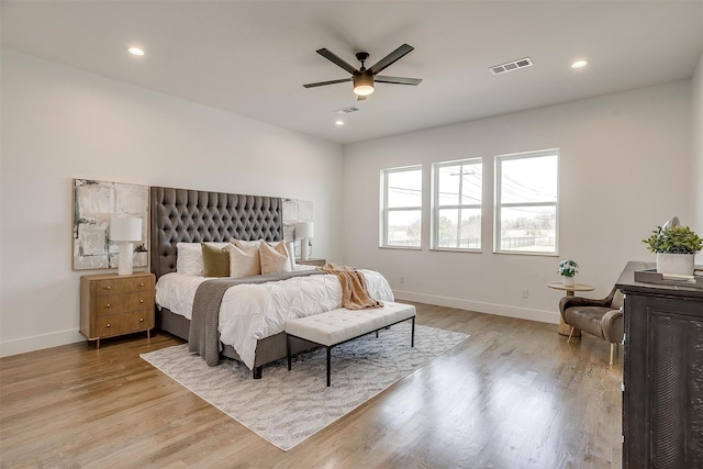 bedroom featuring light wood finished floors, visible vents, and baseboards