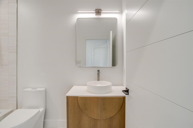 bathroom featuring toilet, vanity, and walk in shower