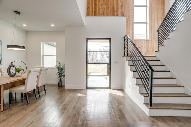 foyer entrance with recessed lighting, baseboards, wood finished floors, and stairs