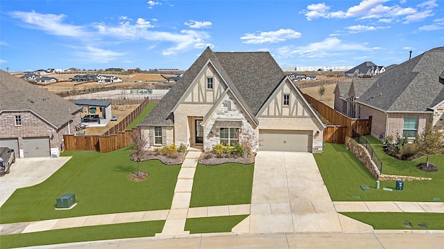 tudor house featuring stucco siding, driveway, a front lawn, and roof with shingles