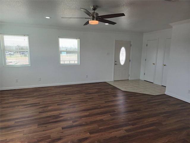 entrance foyer featuring a textured ceiling, crown molding, baseboards, and wood finished floors