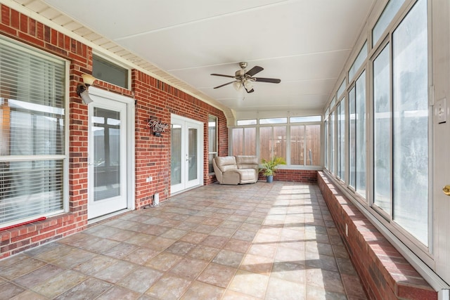 unfurnished sunroom with ceiling fan