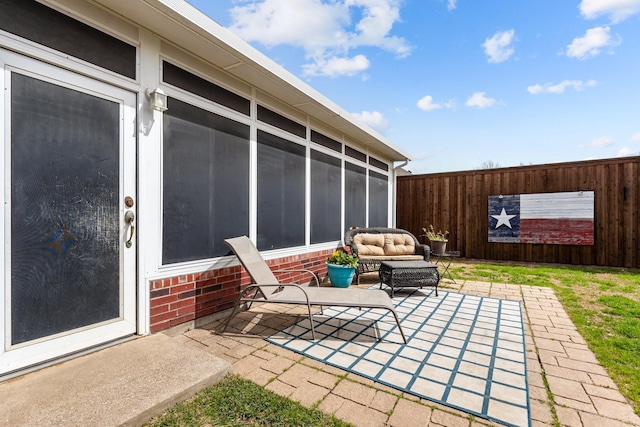 view of patio featuring fence and a sunroom