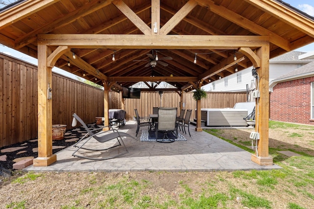 view of patio with outdoor dining space, a gazebo, a fenced backyard, and ceiling fan