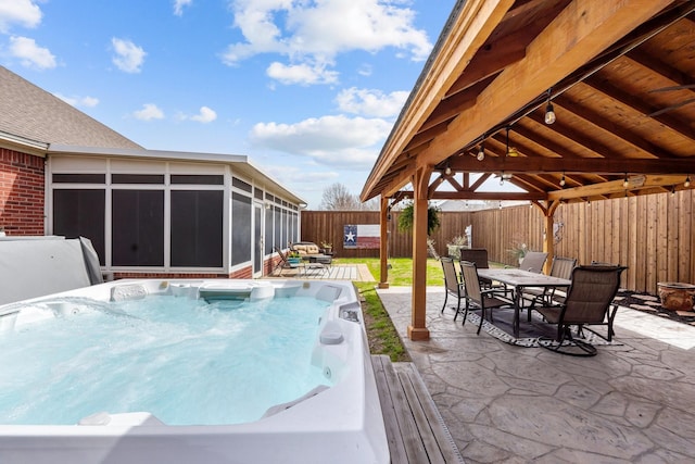 view of pool with a hot tub, a gazebo, a sunroom, a patio area, and outdoor dining space