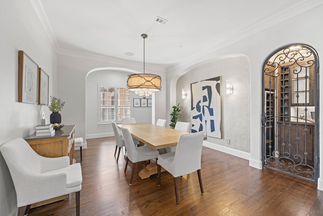 dining area featuring a notable chandelier, baseboards, dark wood-type flooring, and crown molding