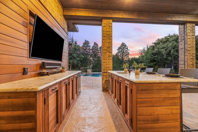 view of patio with a sink, an outdoor pool, and an outdoor kitchen