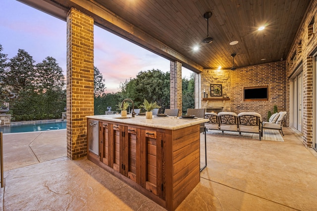 view of patio / terrace with a sink, an outdoor pool, and an outdoor living space with a fireplace