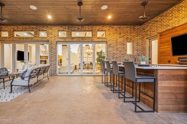 interior space with concrete floors, wood ceiling, brick wall, and recessed lighting