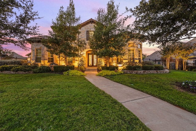 view of front of home featuring stone siding and a yard