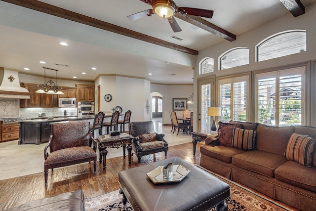 living area featuring visible vents, beam ceiling, recessed lighting, arched walkways, and a ceiling fan