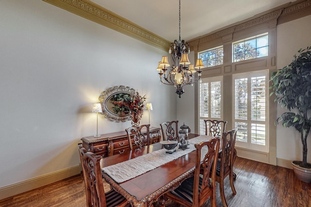 dining area featuring baseboards, a notable chandelier, wood finished floors, and ornamental molding