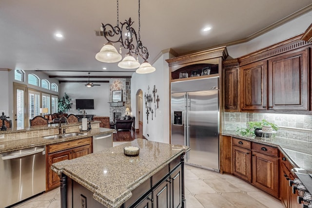 kitchen with a ceiling fan, a sink, backsplash, open floor plan, and stainless steel appliances