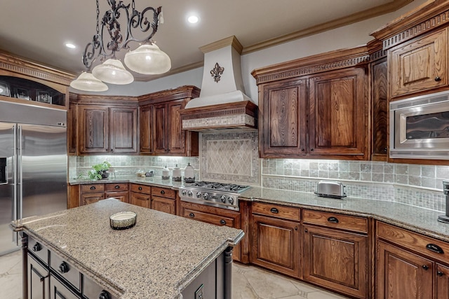 kitchen with light stone counters, built in appliances, backsplash, and custom range hood