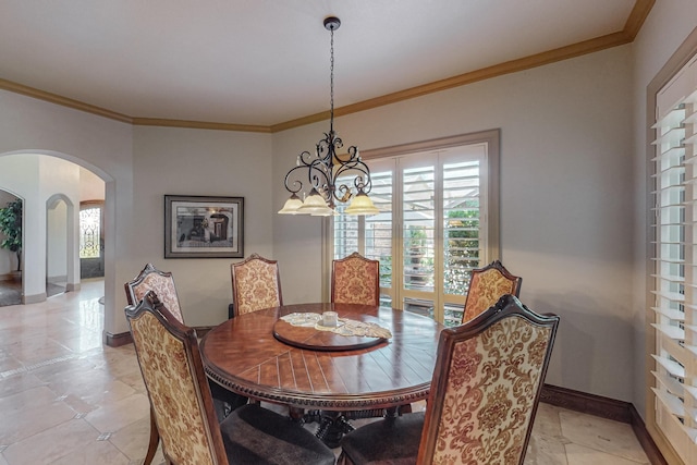 dining room featuring crown molding, baseboards, arched walkways, and a chandelier