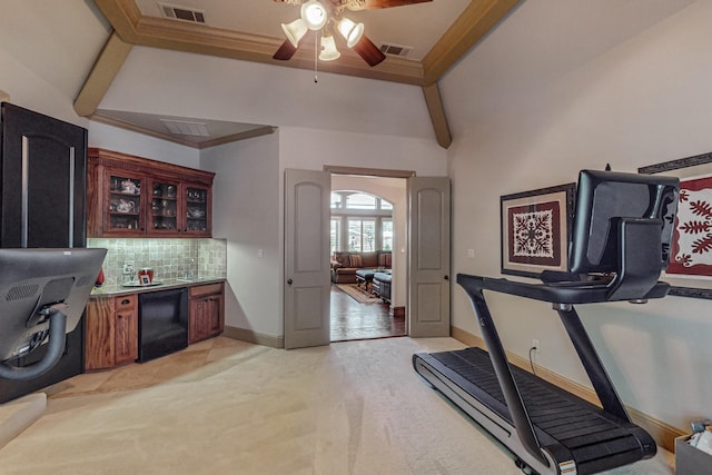 workout area with visible vents, ceiling fan, baseboards, ornamental molding, and light carpet