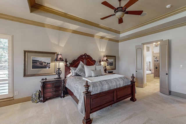 bedroom featuring baseboards, a tray ceiling, ornamental molding, ensuite bathroom, and light colored carpet